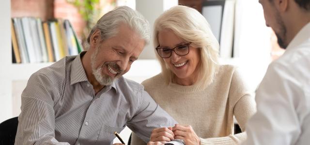 Happy Retiring Business Owner and His Wife in a Meeting with Their Financial Advisor